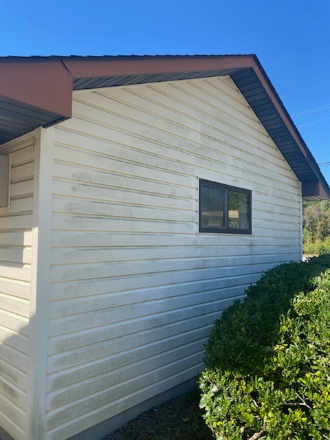 Before: A building's siding that is covered in stains